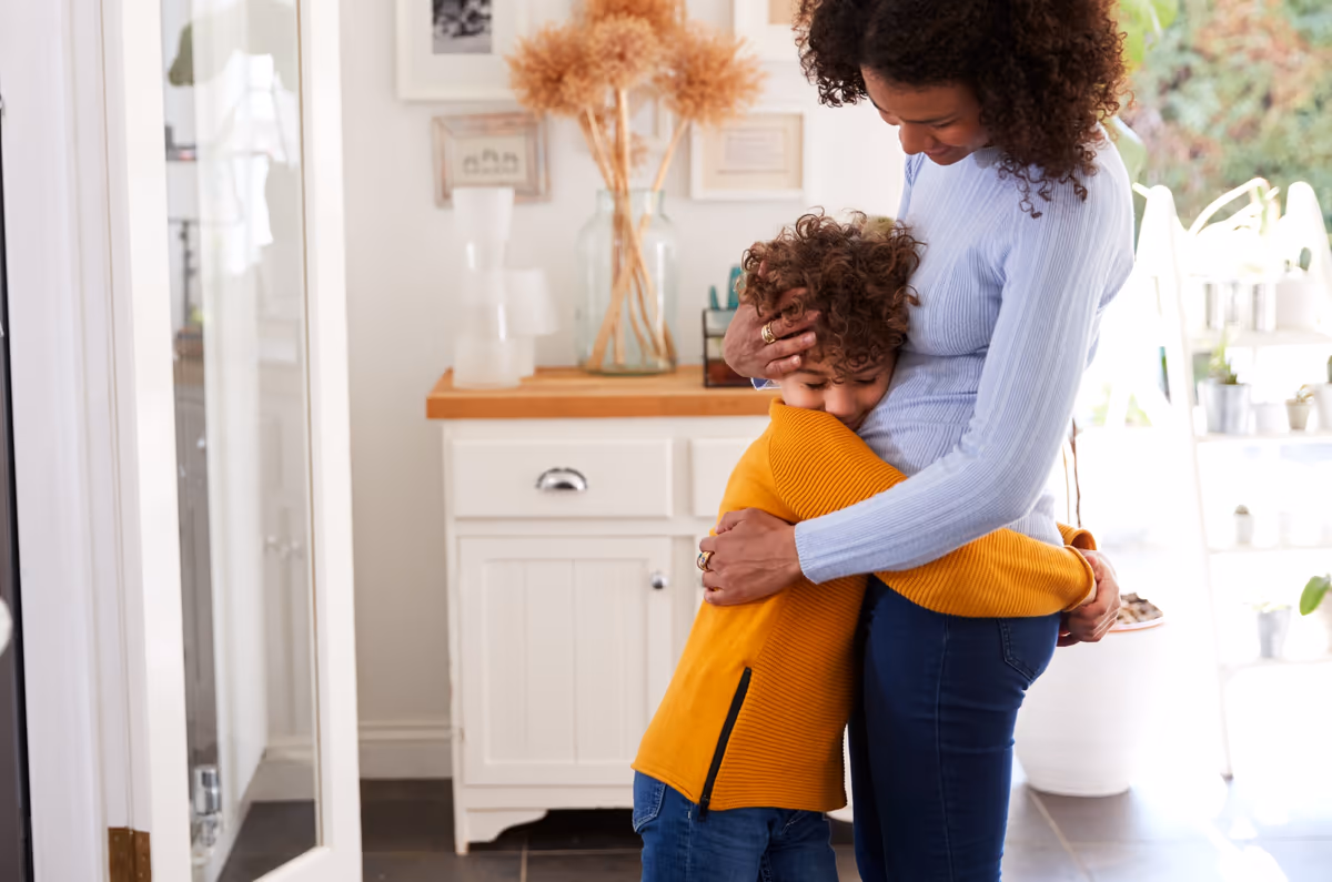 A mother hugging her young son at home
